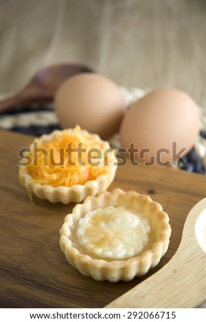 two kinds of sweet mini tarts on wooden board