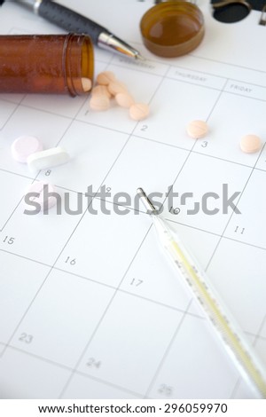 thermometer and pills on blank schedule
