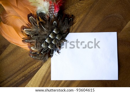 blank white paper note decorated with orange feathers