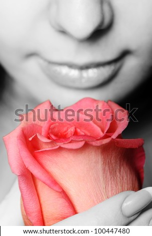 The woman with a rose close up. The monochrome image of the woman and a color rose