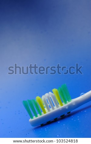 Toothbrush on a blue background with drops of water