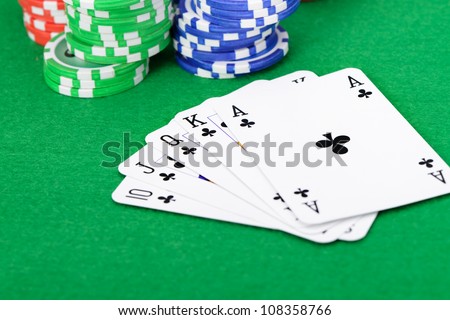 Gaming chips and cards on the green cloth. A winning combination in a poker Royal Flush