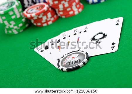 Gaming chips and cards on the green cloth. A winning combination in a poker Royal Flush