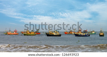 Fishing boats in the ocean . The brightly colored boats moored to the shore of the Indian ocean