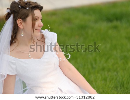 The bride on a lawn. The young girl in a wedding dress.