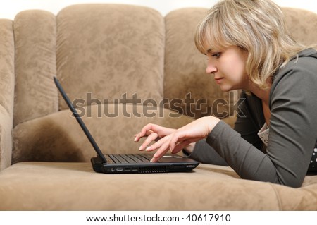 The woman working on laptop at home. House conditions, a sofa.