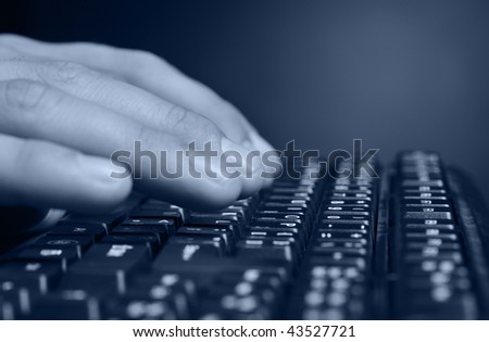 Hands above the keyboard. On a dark background, the black keyboard