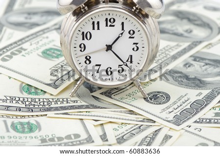 Time - money. Business concept. Analog hours on a heap of paper dollars
