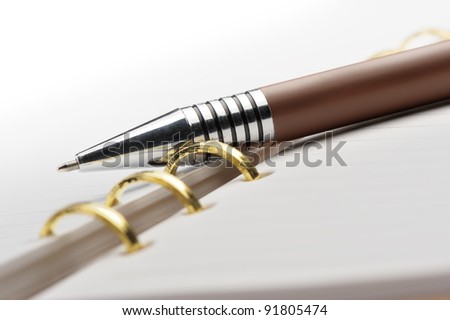 Open notebook with copper binding and stylish pen.