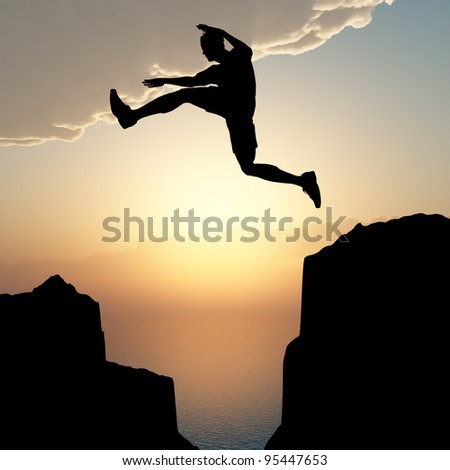 Silhouette of the jumping man from a rock. A sunset