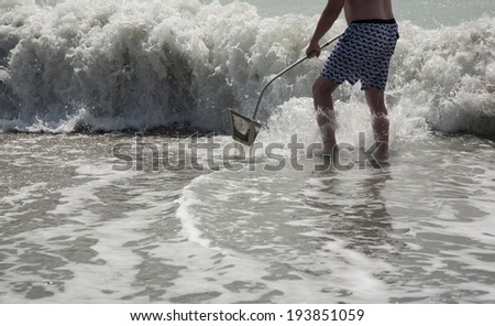 Searching  for shark teeth on Venice beach Florida , using a Florida shovel