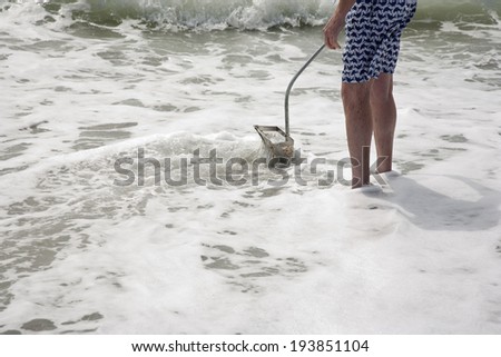 Searching  for shark teeth on Venice beach Florida , using a Florida shovel