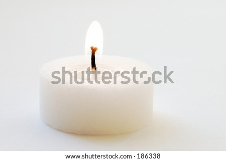 Burning candle on white