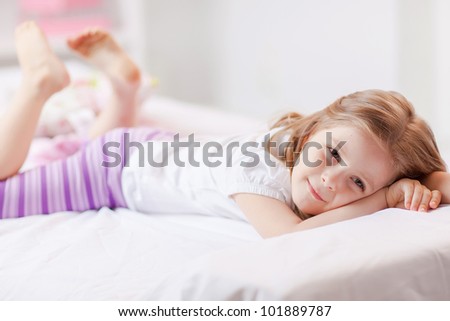 Cute little girl in pajamas on the bed