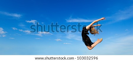 Freedom concept. Dancer jumping against blue sky