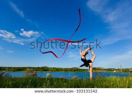 young professional gymnast woman dance with ribbon - outdoor