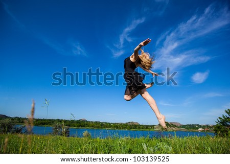 Dancer jumping against blue sky