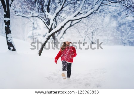 Little winter girl in fairy ice forest smiling