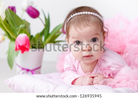 Portrait of adorable baby girl with spring flowers