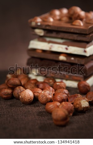 Close-up of stacked assorted chocolate with nuts on brown canvas