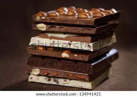 Close-up of stacked assorted chocolate on brown canvas