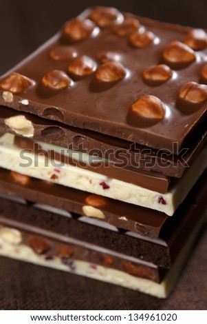 Close-up of stacked assorted chocolate on brown canvas