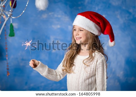 Happy child in santa hat with Christmas bengal fire