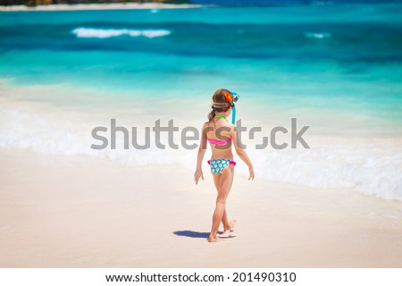 Summer vacation - Kid girl in face masks and snorkels, sea in background.
