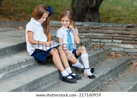 Little girls writting in exercise book in the park