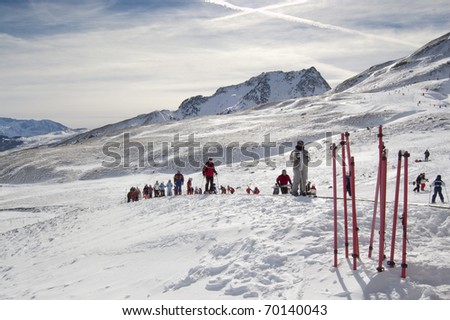 Skiers in a ski resort (Formigal, Huesca, Spain) with close-up of ski sticks.