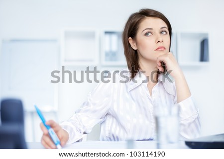 Closeup of relaxed young beautiful young business woman at office