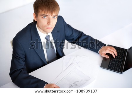 Top view of young businessman working on laptop in office