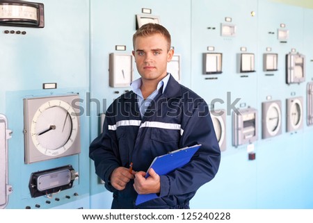 Portrait of young engineer taking notes at control room