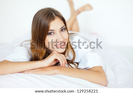 Beautiful happy smiling young woman on bed