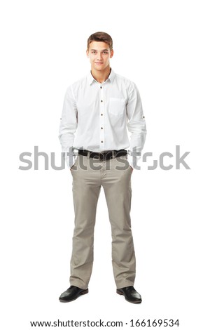 Full length portrait of young man wearing white shirt and light trousers with hands in pockets isolated on white background