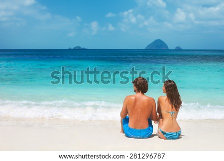 Couple sitting together on a beautiful tropical beach