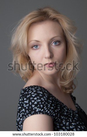 Young beautiful  blonde woman in  black dress with hearts looking at the camera close-up