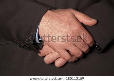 Man in suit folded his hands in front of him closeup