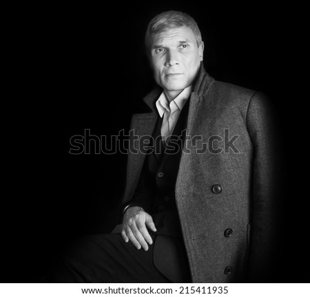 Man in coat at the age of forty-six years on black  background