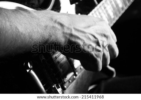 Man  playing guitar on a black background closeup