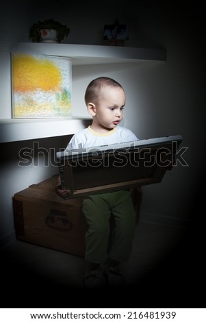 Adorable  little boy at the age of two in a white T-shirt  lookingat the picture