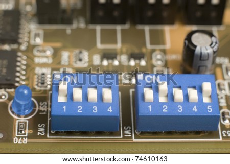 macro of small blue switches and blue led on circuit board