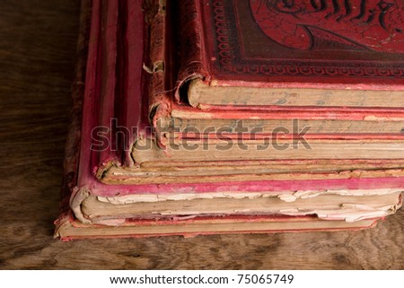 antique hardly used books with red covers on wooden table
