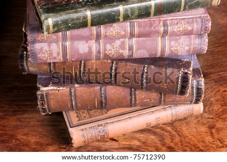 stack of antique books  backs on aged wooden background taken from archive