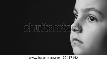 black and white girl\'s face on black background is thinking and looking away