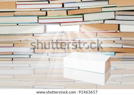 Rays of light falling on a white book on the background of many books.
