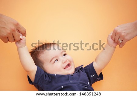 Stock image of a baby being held by adult hands