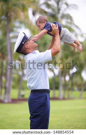 Stock image of a man raising his baby in the air
