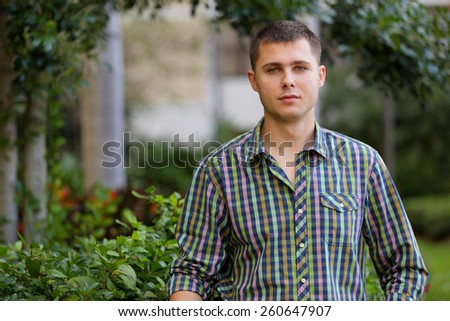 Casual Russian man posing in a garden