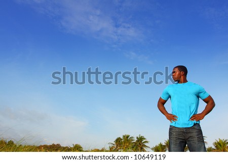 Man With Arms At Hips with Blue Sky Background